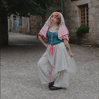 Tenue de mariée Anouchka. Une vibe à la fois cottage core, pays de l’est, mais aussi punk pour un look qui claque !! Composée d’un corset avec manches et grand col, et d’un pantalon avec sur jupe intégrée, ainsi que d’un voile assorti