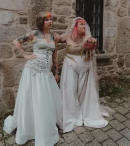 Deux mariées aux styles assumés, punk et moderne rock, robe de mariée ou tenue de mariée avec top et pantalon, ou bustier avec guêpière et jupe longue à traîne, avec ou sans voile