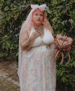 Robe de mariée sur mesure mêlant simplicité et originalité avec une dentelle à sequins colorés, décolleté devant et dos nu, portée avec un voile à sequins original