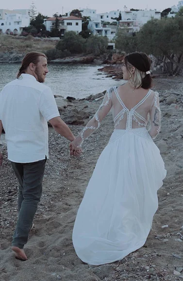 Olympe dans sa robe de mariée sur mesure en tulle avec broderies appliquées à la main, sur la plage avec son mari