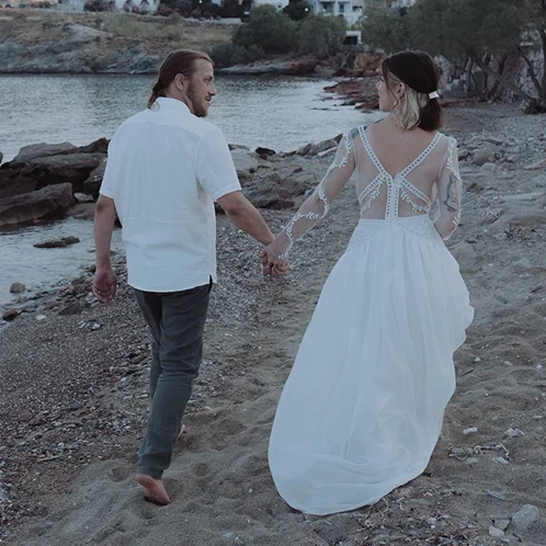Olympe dans sa robe de mariée sur mesure en tulle avec broderies appliquées à la main, sur la plage avec son mari