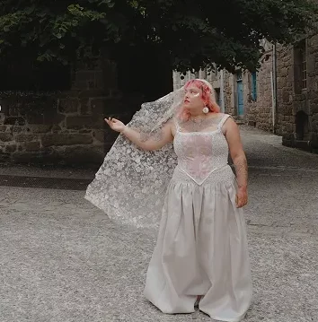Tenue de mariée Themis. Rose est composée d’un bustier esprit cottage core agrémenté d’une dentelle de Calais, et d’une jupe avec ceinture asymétrique avec dentelle de calais assortie au haut et organza, ainsi que d’un voile de sequins.